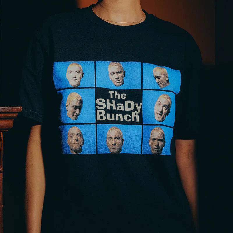 Close-up of the SSLP25 Shady Bunch T-shirt, showcasing a creative display of Eminem's alter egos against a blue background, reminiscent of a famous TV show's style.