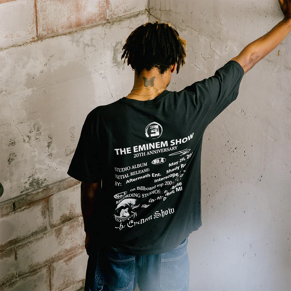 Rear view of a person wearing 'The Eminem Show 20th Anniversary T-Shirt' featuring album details and iconic graphics, celebrating Eminem's influential album.