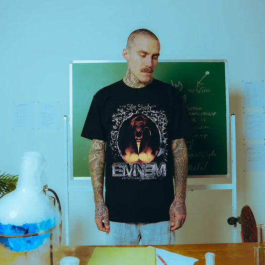 Model in a classroom sporting the Eminem SSLP25 Portrait T-shirt with a striking front graphic celebrating The Slim Shady LP's 25th anniversary.